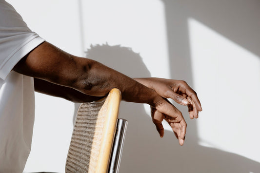 Man-standing-with-hands-on-chair