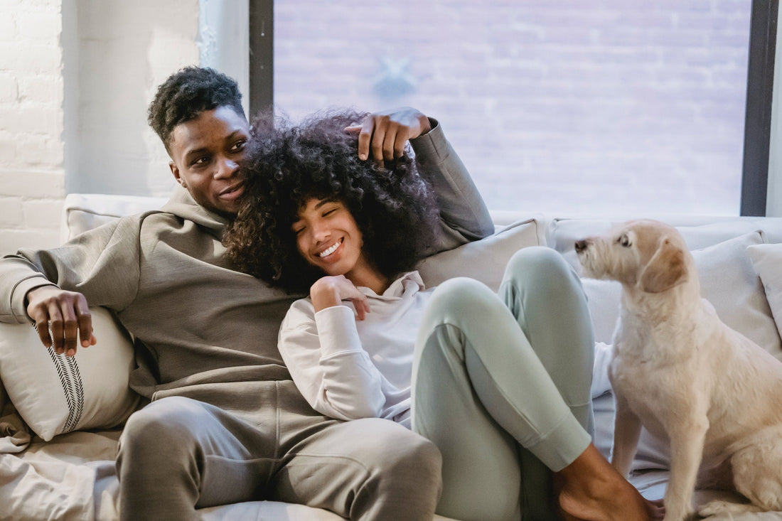 A-couple-relaxing-on-couch-with-dog