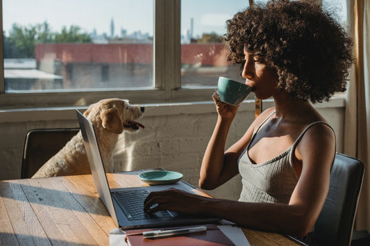 Girl-drinking-coffee-and-working-with-dog