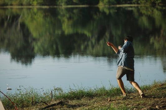 Man-throwing-stones-by-lake